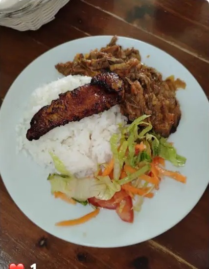 Plato de arroz con carne mechada, maduro y ensalada fresca
