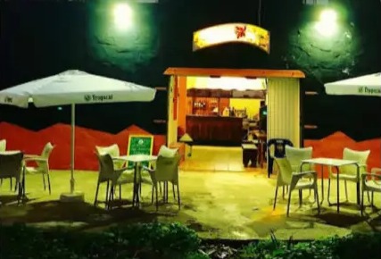 Terraza de La Sabrosura iluminada de noche con mesas preparadas