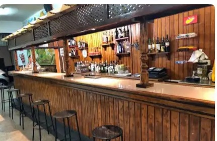 Barra de madera del bar con taburetes y botellas