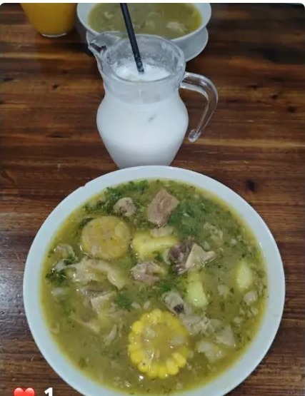 Sancocho colombiano con maíz, papa y carne, acompañado de jarra